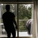 man looking out sliding glass doors
