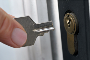 Person holding half a key near a lock