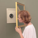 Woman Looking at Safe Hidden Behind Painting