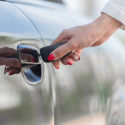 hand holding car key into car door